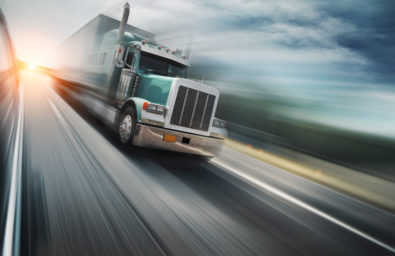 Truck On Freeway Big freight truck speeding on freeway at sunset. Copyspace.