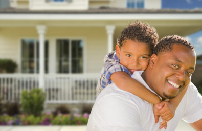 Happy Playful African American Father and Mixed Race Son In Fron Happy Playful African American Father and Mixed Race Son In Front of House.