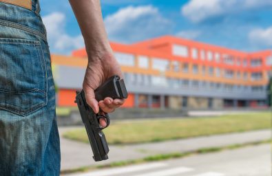 Gun Control Concept. Young Armed Man Holds Pistol In Hand In Pub Gun Control Concept. Young Armed Man Holds Pistol In Hand In Pub